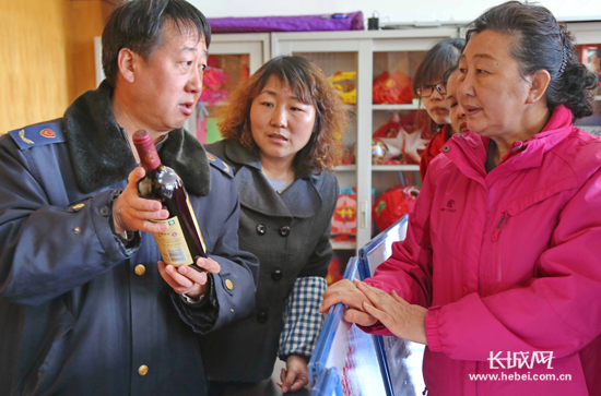 工作人員為天洋新城社區(qū)居民講解紅酒的鑒別方法。