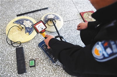 民警展示盜墓團(tuán)伙使用的金屬探測(cè)儀。圖/新華社
