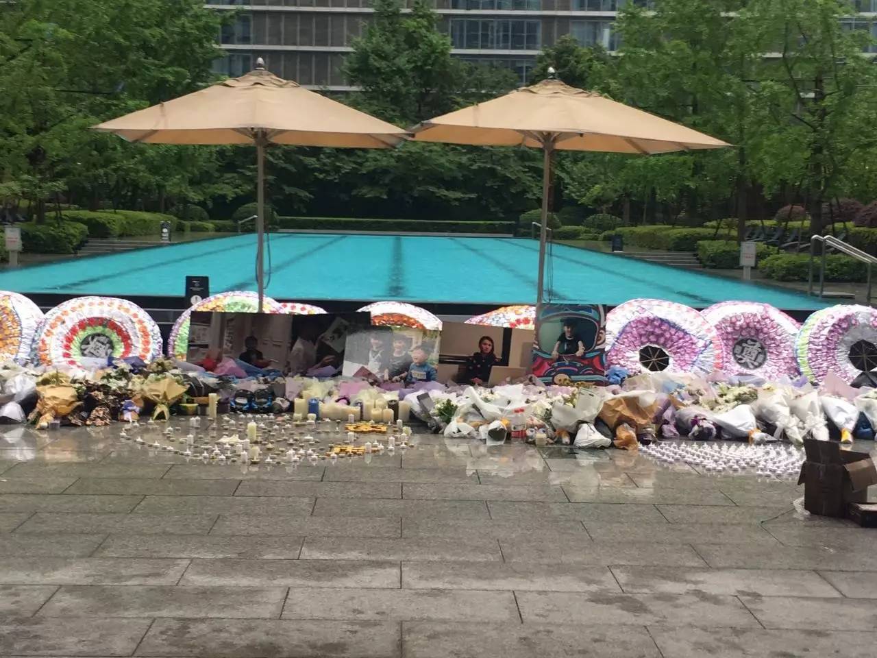 火災(zāi)后，小區(qū)業(yè)主自發(fā)組織悼唁活動(dòng)，草坪上逝者照片前擺滿了花圈、花束、蠟燭。（新京報(bào)記者王婧祎攝）